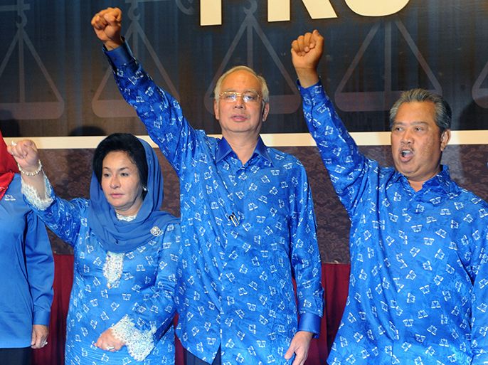 Malaysian Prime Minister Najib Razak (C), his wife Rosmah Mansor (L) and deputy Prime Minister Muhyiddin Yassin celebrate the Barisan Nasional (National Front) coalition electoral victory, on May 6, 2013 in Kuala Lumpur. Country's Election Comission said the ruling Barisan Nasional coalition led by Premier Najib Razak secured 112 parliamentary seats, the threshold required to form a government in the 222-seat chamber. Malaysians voted in record numbers in the general election but the hotly anticipated day was dogged by accusations of electoral irregularities.     AFP PHOTO / ROSLAN RAHMAN
