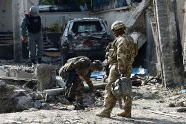 NATO-led International Security Assistance Force (ISAF) soldiers investigate debris at the site of a suicide attack in Kabul on May 25, 2013. Explosions rocked central Kabul for several hours on May 24, after Taliban gunmen launched a major suicide and gun attack centred on a compound of the International Organization for Migration (IOM). One police officer was killed and five militants were shot dead as security forces hunted down the attackers, with prolonged bursts of gunfire and grenade blasts heard across the Afghan capital. AFP PHOTO/ SHAH Marai