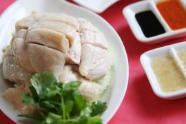 epa00888542 The Hainanese chicken rice dish in a branch of famous chicken rice restaurant Boon Tong Kee in Singapore on Monday 18 December 2006. The hugely popular chicken rice chain restaurant can sell from 80 to 100 chickens in a day at a single branch to hungry customers. The chicken rice dish originating from the island of Hainan in China, is one of the most popular dish in Singapore and is often considered as one of the national dishes of the city-state. Food in south east Asian nations is a varied, delicious mixed bag of fresh meat, fish and vegetables, combined in a spicy sweet and sour array of mouth watering dishes. Many dishes are cooked on the street at food markets, and the same dishes served in high end restaurants. Everyone can afford to eat out at one or the other. EPA/HOW HWEE YOUNG