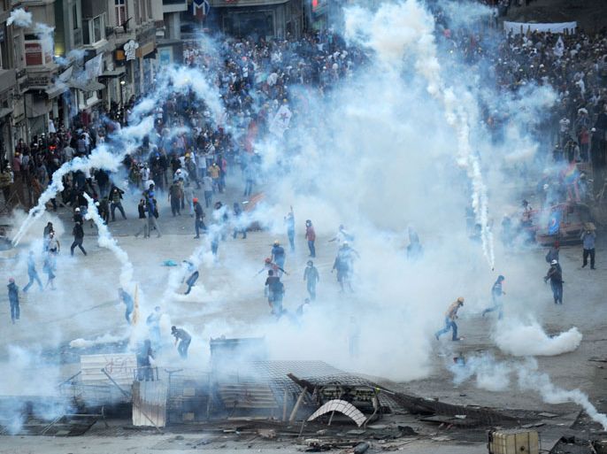 Protestors clash with Turkish riot policemen on Taksim square on June 11, 2013. Turkish police fired massive volleys of tear gas and jets of water to disperse thousands of anti-government demonstrators in Istanbul's Taksim Square on June 11, after earlier apparently retreating, an AFP reporter saw. The gas sent the crowd scrambling, raising tensions on a 12th day of violence after Prime Minister Recep Tayyip Erdogan warned he had "no more tolerance" for the mass demonstrations.
