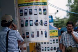 , -, MYANMAR : People speaks on mobile phones in Yangon on June 27, 2013. Myanmar on June 27 awarded telecom licences to Norway's Telenor and Qatari firm Ooredoo, the government committee in charge of the bids said, opening up one of the world's last virtually untapped mobile phone markets. AFP PHOTO