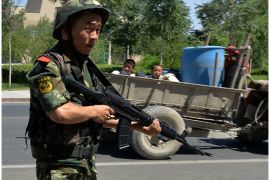 CHINA : Chinese paramilitary police man a checkpoint on the road to the riot affected Uighur town of Lukqun, Xinjiang province, on June 28, 2013. Fresh violence erupted in China's restive Xinjiang on June 28, state media said, two days after 35 died in what the government called a "terrorist attack" and a week before the anniversary of major 2009 clashes