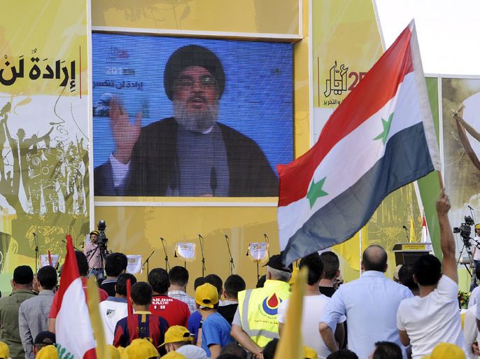 epa03717034 Supporters of Hezbollah listen to the Secretary General of Hezbollah Sayyed Hassan Nasrallah, speaking on a giant screen via video link from an undisclosed location, during a rally to mark the Resistance and Liberation Day, in the village of Mashghara, in the eastern Bekaa valley, Lebanon, 25 May 2013. The Liberation Day commemorates the Israeli army's withdrawal from south Lebanon in May 2000 following 22 years of occupation. EPA/WAEL HAMZEH