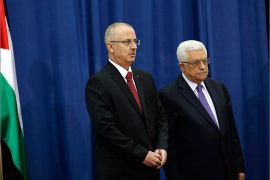 Palestinian Prime Minister Rami Hamdallah (L) stands with President Mahmoud Abbas during a swearing-in ceremony of the new government in the West Bank city of Ramallah June 6, 2013. Hamdallah and his West Bank-based government were sworn in on Thursday and one of their main challenges will be reaching a power-sharing deal with the Islamist Hamas movement ruling Gaza. REUTERS/Mohamad Torokman (WEST BANK - Tags: POLITICS)