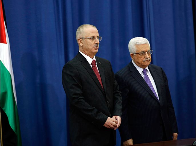 Palestinian Prime Minister Rami Hamdallah (L) stands with President Mahmoud Abbas during a swearing-in ceremony of the new government in the West Bank city of Ramallah June 6, 2013. Hamdallah and his West Bank-based government were sworn in on Thursday and one of their main challenges will be reaching a power-sharing deal with the Islamist Hamas movement ruling Gaza. REUTERS/Mohamad Torokman (WEST BANK - Tags: POLITICS)