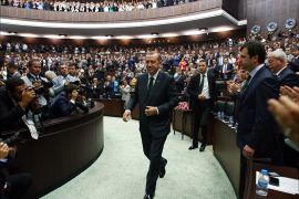 Turkish Prime Minister Recep Tayyip Erdogan is applauded by members of parliament from his ruling Justice and Development Party (AKP) during a meeting at the Turkish parliament in Ankara on June 25, 2013. Erdogan yesterday praised the police "heroism" in handling several weeks of unrest that threw up the biggest challenge yet to his government after more than a decade in power. AFP PHOTO/ADEM ALTAN