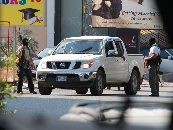 مسلحان من أنصار الأسير يمنعان سيارة من التقدم في أحد شوارع عبرا (رويترز)