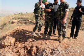 Soldiers inspect the crater caused by a rocket fired from Syria that hit Lebanon's eastern Bekaa region, causing no casualties, on June 1,2013. Six rockets hit the Bekaa region, between Saraain al-Fawqa and Saraain al-Tahta near the Rayaq airport, in the latest spillover from the more than two-year conflict in Lebanon's larger neighbour, a security source said. AFP PHOTO STR