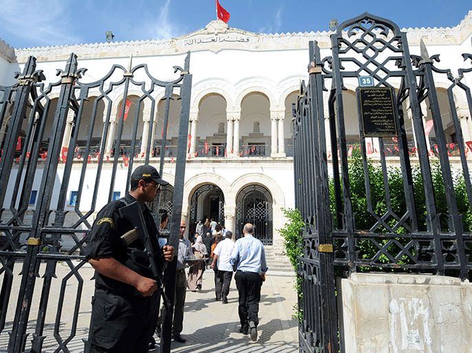 A policeman stands guard in front of the court in Tunis on June 5, 2013 where three European women who bared their breasts in the Tunisian capital last week will go on trial. Three European women went on trial in Tunis for holding a topless anti-Islamist protest, and their French lawyer said he was confident they would escape prison despite the threat of jail sentences. AFP PHOTO / FETHI BELAID