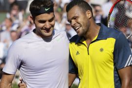 Switzerland's Roger Federer (L) is comforted by France's Jo-Wilfried Tsonga at the end of their French Tennis Open quarter final match at the Roland Garros stadium in Paris, on June 4, 2013. AFP PHOTO / KENZO TRIBOUILLARD