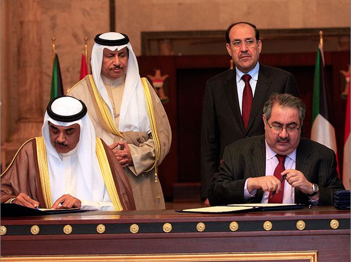 epa03741648 Iraqi Prime Minister Nouri al-Maliki (R-back) and his Kuwait counterpart Sheikh Jaber Al Mubarak Al Hamad Al Sabah (L-back) look on as Iraqi Foreign Minister Hoshyar Zebari (R-front) and Kuwaiti Foreign Minister Sheik Sabah Khalid Al Hamad Al Sabah (L-front) sign agreements in Baghdad, Iraq, 12 June 2013. Kuwaiti Prime Minister arrived in Baghdad with a high-level delegation on an official visit during which he will have talks with Iraqi officials. The two sides signed a series of agreements aimed at improving bilateral ties in the economic, transportation and other sectors. EPA/KARIM KADIM POOL