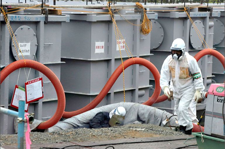 A worker walks in front of water tanks at Tokyo Electric Power Company's (TEPCO) tsunami-crippled Fukushima Daiichi nuclear power plant in Fukushima prefecture in this June 12, 2013 file photo. High levels of a toxic substance called strontium-90 have been found in groundwater at the devastated Fukushima nuclear power plant in Japan, the utility that operates the facility said on Wednesday. Testing of groundwater outside the turbine building of reactor No. 2 had shown the level of strontium-90 had increased by more than 100 times between December 2012 and May this year, Toshihiko Fukuda, a general manager at TEPCO, told a news conference. REUTERS/Noboru Hashimoto/Pool/Files (JAPAN - Tags: DISASTER BUSINESS ENERGY ENVIRONMENT)