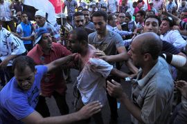 Egyptians help a wounded man following clashes between supporters and opponents of President Mohamed Morsi in the coastal city of Alexandria on June 28, 2013. Supporters and opponents of Morsi took to the streets for rival protests a year after his election, as clashes in Alexandria raised fears of widespread unrest. Fervent displays of emotion on both sides underline the bitter divisions in Egypt, with Morsi's opponents accusing him of hijacking the revolution and his supporters vowing to defend his legitimacy to the end. AFP PHOTO/STR