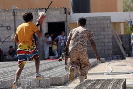 TOPSHOTSMembers of Libyan security forces run away holding weapons during clashes between protesters and troops of the Libyan Shield Forces (LSF), a coalition of militias, following a demonstration outside the LSF office in the northern city of Benghazi on June 8, 2013.