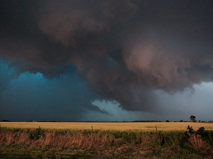 Large clouds are seen as a tornado passes south of El Reno, Oklahoma May 31, 2013. Violent thunderstorms spawned tornadoes that menaced Oklahoma City and its already hard-hit suburb of Moore on Friday, killing a mother and her baby, and officials worried that drivers stuck on freeways could be trapped in the path of dangerous twisters. One twister touched down on Interstate 40 and was headed toward Oklahoma City. REUTERS/Bill Waugh (UNITED STATES - Tags: DISASTER ENVIRONMENT TPX IMAGES OF THE DAY)
