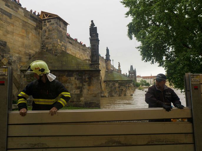 DG337 - Prague, BOHEME, CZECH REPUBLIC : Members of the emercengy services build anti-flood barriers on the left bank of Vlatva river near the Charles Bridge on June 02, 2013 in Prague. After another night of downpours in the capital and elsewhere in the Czech Republic the water in Vltava was still on the rise and expected to reach critical levels later in the day AFP PHOTO / MICHAL CIZEK