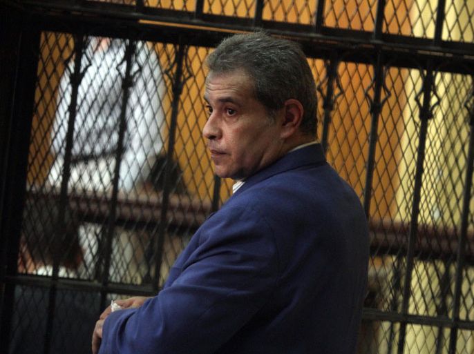 epa03378280 Television talk show host Tawfiq Okasha looks on inside a cage in the courtroom, during the first hearing of his trial in Cairo, Egypt, 01 Sepetember 2012. Okasha, a critic of Morsi's Muslim Brotherhood, Egypt's largest political group is accused of inciting violence against Morsi. Okasha's privately owned Al-Faraeen broadcaster, which means the Pharaohs, was taken off the air for a month after he suggested that the Brotherhood was behind militant attacks that killed 16 Egyptian soldiers in the Sinai Peninsula. Okasha's trial has been adjourned to 03 October 2012. EPA/AHMED KHALED