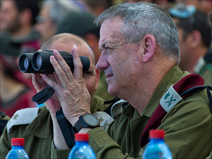 epa03730883 Israeli Chief of Staff Lt. General Benny Gantz holds a pair of binoculars as he views the large combined army forces drill on the Shizafon army base, north of Eilat, Israel, 04 June 2013. Gantz said the Israeli armed forces will streamline its operations, and 'be up to the difficult task' of operating under some austerity measures as budget cuts take hold on the Israeli Defense Forces. EPA/JIM HOLLANDER