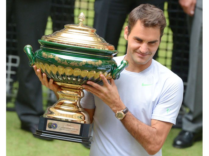 HALLE, GERMANY - JUNE 16: Roger Federer of Switzerland lifts the winners cup after the final match against Mikhail Youzhny of Russia during the final day of the Gerry Weber Open at Gerry Weber Stadium on June 16, 2013 in Halle, Germany. (Photo by Thomas Starke/Bongarts/Getty Images)