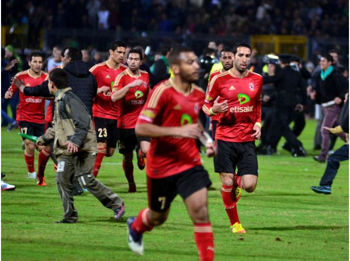 epa03088509 Al-Ahly soccer team players (in red) leave the pitch as soccer fans of the opposing team run towards them, after clashes erupted after a soccer match between Al-Ahly and Al-Masri at the stadium of Port Said, Egypt, 01 February 2012. At least 70 people were killed and 200 injured on 01 February when riots broke out following a football match in northern Egypt, according to local media reports. Some of the dead are believed to be security officers. The riots broke out after a game between Egypt's Al-Ahali and Al-Masri teams in Port Said, the Egyptian broadcaster said. EPA/STRINGER EPA/STRINGER
