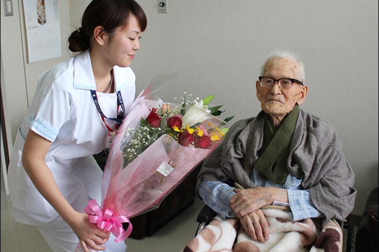 (FILES) This picture taken by the Kyotango City Government on December 26, 2012 shows the world's oldenst man Jiroemon Kimura (R) receiving a flower bouquet from a nurse at a hospital in Kyotango, Kyoto prefecture in western Japan. The world's oldest person and the oldest man Kimura died of natural causes in a hospital in Kyotango on June 12, 2013 at the age of 116. AFP