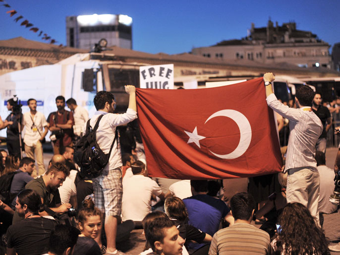 متظاهرون على أطراف ميدان تقسيم بإسطنبول (الفرنسية)