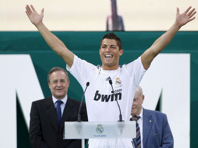 epa01785395 Real Madrid's new signing, Portuguese striker Cristiano Ronaldo (front), greets spectators from a stage placed at the Santiago Bernabeu stadium during his official presentation in Madrid, central Spain, 06 July 2009. Behind him are Real Madrid president, Florentino Perez (L), and Real Madrid honorary president, Alfredo Di stefano (R). EPA/JUAN CALOS HIDALGO