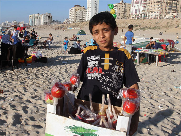محمد يبيع العنبر لمساعدة والده في مصروف العائلة (الجزيرة نت)