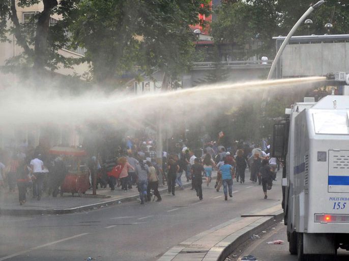 Protesters run away from a water cannon during a demonstration in Ankara on June 5, 2013. Thousands of striking workers took to the streets of Turkey's cities today, loudly joining calls for Prime Minister Recep Tayyip Erdogan to step down as mass protests against his rule intensified. Bellowing to the din of drums and wailing Turkish pipes, teachers, doctors, bank staff and others marched in a sea of red and yellow labour union flags in the capital Ankara and in Istanbul, where they converged on Taksim Square, the cradle of nearly a week of violent clashes.