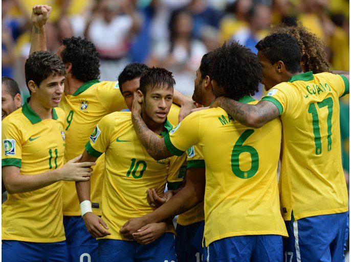 Brazil's forward Neymar (C) is congratulated by teammates after scoring against Japan during their FIFA Confederations Cup Brazil 2013 Group A football match, at the National Stadium in Brasilia on June 15, 2013. AFP PHOTO / VANDERLEI ALMEIDA