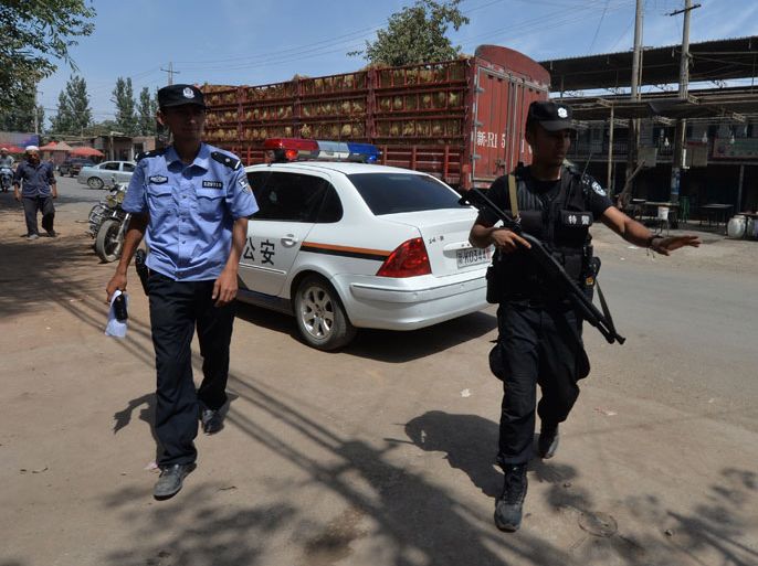 Armed Chinese police patrol the road leading into the riot affected town of Lukqun, Xinjiang Province on June 27, 2013. Riots in China's ethnically divided Xinjiang region left 27 people dead, after police opened fire on "knife-wielding mobs". It was the latest spasm of violence to hit the troubled western region, which is about twice the size of Turkey and is home to around 10 million members of the mostly Muslim Uighur ethnic minority. AFP