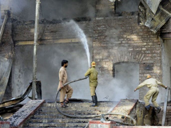 PAKISTAN : Pakistani firefighters extinguish a blaze which gutted a historial building in Ziarat, 80 kilometres southeast of Quetta, on June 15, 2013