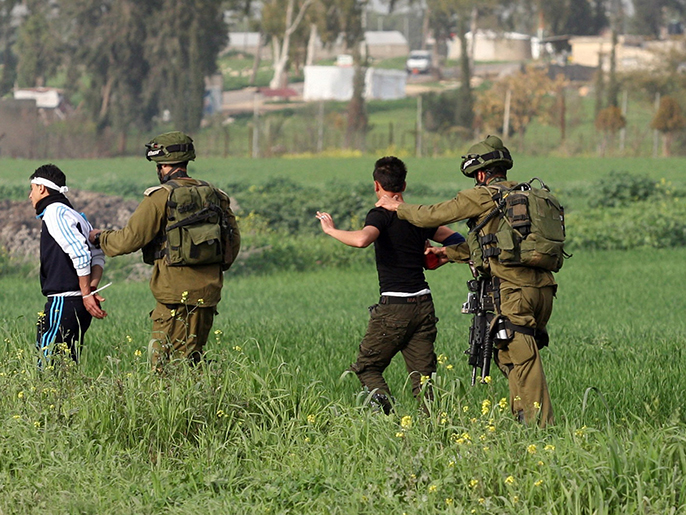 ‪جنود إسرائيليون يعتقلون شبانا فلسطينيين‬ (الفرنسية)