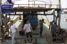 المتضامن الأجنبي وعضو أسطول الحرية تشارلي اندريسون وعدد من العمال الفلسطينيين يعملون على تحويل المركب من مركب صيد الى مركب لمق البضائع.
