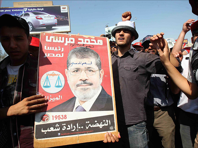 ‪‬ متظاهرون يرفعون صور الرئيس محمد مرسي(الجزيرة)