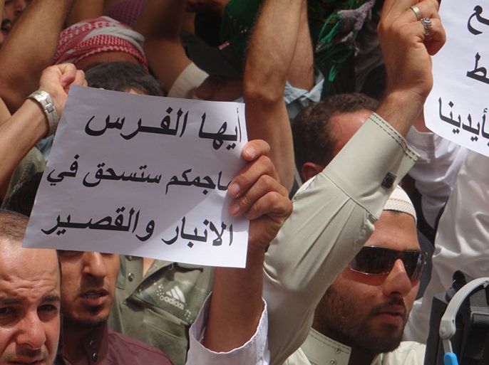 1 أحد المعتصمين يحمل شعارا يدين فيه التدخل الإيراني بالشأن العراقي – خاص بالجزيرة نت