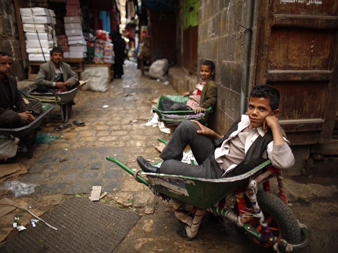 Boys and men working in ferrying goods wait to be hired at a marketplace in Old Sanaa city January 8, 2013. REUTERS/Khaled Abdullah (YEMEN - Tags: SOCIETY)