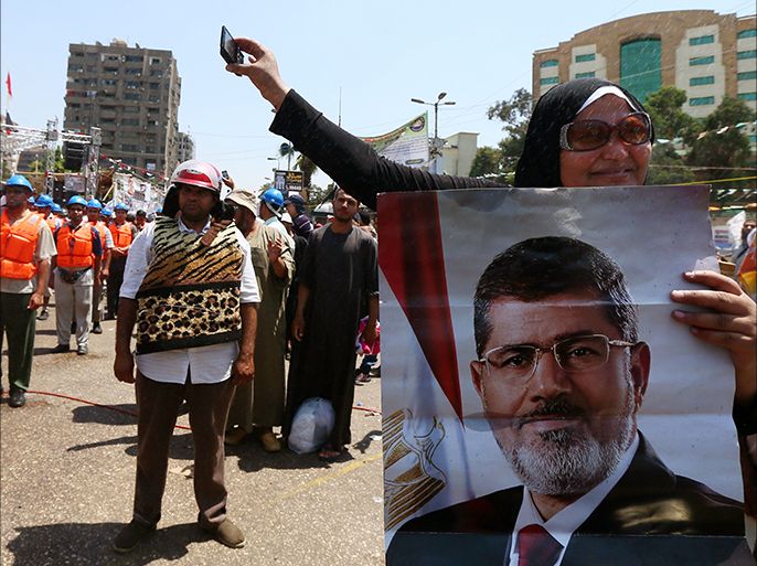 Egyptian supporters of Muslim Brotherhood and Egypt's ousted president Mohamed Morsi (on the poster) take part in a self-defense training outside Rabaa al-Adawiya mosque on July 16, 2013 in Cairo. Egyptian security forces arrested more than 400 supporters of Morsi in one part of Cairo alone following deadly clashes overnight, a security source said. AFP PHOTO/MARWAN NAAMANI