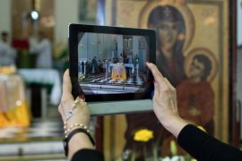 A woman takes a snapshot with her iPad of the altar with the relics of blessed John Paul II at the Medalha Milagrosa sanctuary in Rio de Janeiro, Brazil, on July 7, 2013.