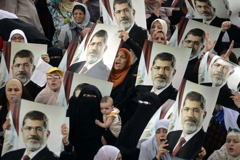Female Egyptian supporters of the Muslim Brotherhood hold up portraits of Egypt's ousted president Mohamed Morsi during a rally in Cairo on July 21, 2013. Supporters of Morsi, who has been held in custody since his ouster on July 3, view the army's decision to overthrow the man they voted into power last year as an affront to democracy