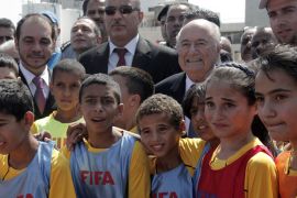 FIFA President Sepp Blatter (C-R) poses for a picture with Palestinian children during the opening ceremony of Jamal Ghanem Stadium in the West Bank town of Tulkarm July 7, 2013. AFP PHOTO/JAAFAR ASHTIYEH