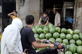 A boy sells watermelons before the time for iftar, or breaking fast, during the Islamic holy month of Ramadan in the city of Aleppo July 13, 2013. REUTERS/Muzaffar Salman (SYRIA - Tags: FOOD SOCIETY RELIGION)
