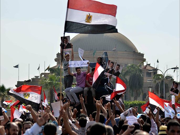 Supporters of Islamist Egyptian President Mohamed Morsi hold pictures of him during a rally by mainly Muslim Brotherhood partisans outside Cairo University on June 2, 2013. A top Muslim Brotherhood leader urged Egyptians to stand ready to sacrifice their lives to prevent a coup, after the army gave Islamist President Mohamed Morsi and his opponents until June 3 to resolve their differences or face intervention. AFP PHOTO/MOHAMED EL-SHAHED