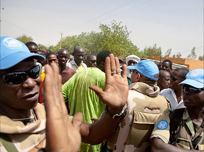 United Nations peacekeepers try to calm a crowd during a protest against sending peacekeepers from Senegal to the northern rebel-held town of Kidal before sending Malian soldiers there, in Gao July 5, 2013. About 500 people from different youth organizations rallied in front of the camp where Senegalese peacekeepers for the UN mission in Mali, MINUSMA, are stationed on Friday. REUTERS/Malin Palm (MALI - Tags: POLITICS CIVIL UNREST)