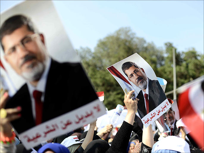‪متظاهرون بالقاهرة يرفعون صورة مرسي في مظاهرة مناهضة للانقلاب‬ (الفرنسية)