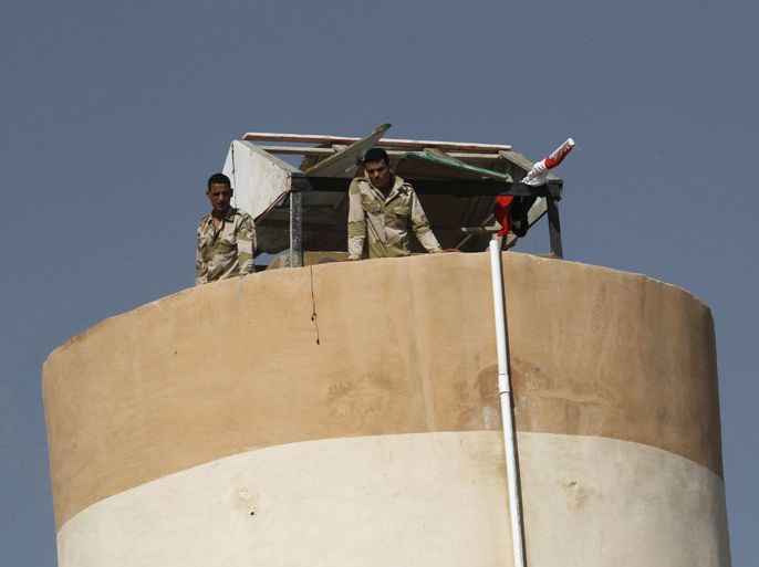 A picture taken from Rafah in the southern Gaza Strip on the border with Egypt, on July 5, 2013 shows two Egyptian soldiers standing on top of a watch tower. An Egyptian soldier was killed early today in coordinated rocket and machinegun attacks by Islamist militants on army checkpoints and a police base in the restive Sinai, medics said.