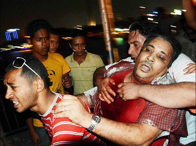 epa03777287 An injured Egyptian man is taken away as supporters and opponents of former President Morsi clash against each other on 06 October bridge in Cairo, Egypt, 05 July 2013. According to reports, shots were fired during a gathering of supporters of ousted Egyptian President Mohamed Morsi in Cairo, leaving at least three man killed. Backers of Morsi on 05 July staged huge protests across Egypt, where fighting between the Islamist leader's supporters and opponents have raised fears of deadly street violence in the Arab world’s most populous country. EPA/ALI SABAA