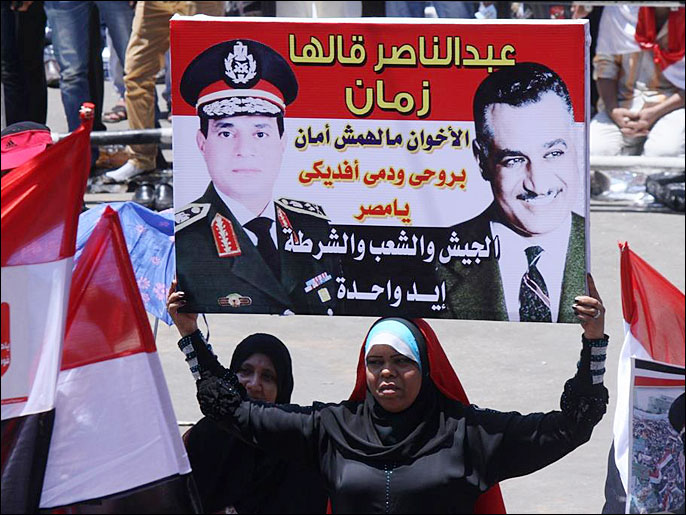 ‪متظاهرة تحمل صورة للسيسي‬ (الجزيرة)