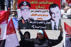 متظاهرة تحمل صورة للسيسي مع جمال عبد الناصر.