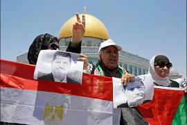 Palestinian women hold pictures of ousted Egyptian President Mohamed Mursi and an Egyptian flag (L) during a pro-Mursi demonstration before prayers on the compound known to Muslims as Noble Sanctuary and to Jews as Temple Mount in Jerusalem's Old City, on the first Friday of the holy month of Ramadan July 12, 2013. The Dome of the Rock is seen in the background. REUTERS/Ammar Awad (JERUSALEM - Tags: RELIGION POLITICS CIVIL UNREST)